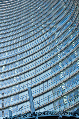 Glass Facade of company building with reflection of blue sky.