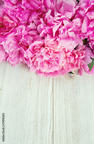 pink peonies on wooden surface © Diana Taliun