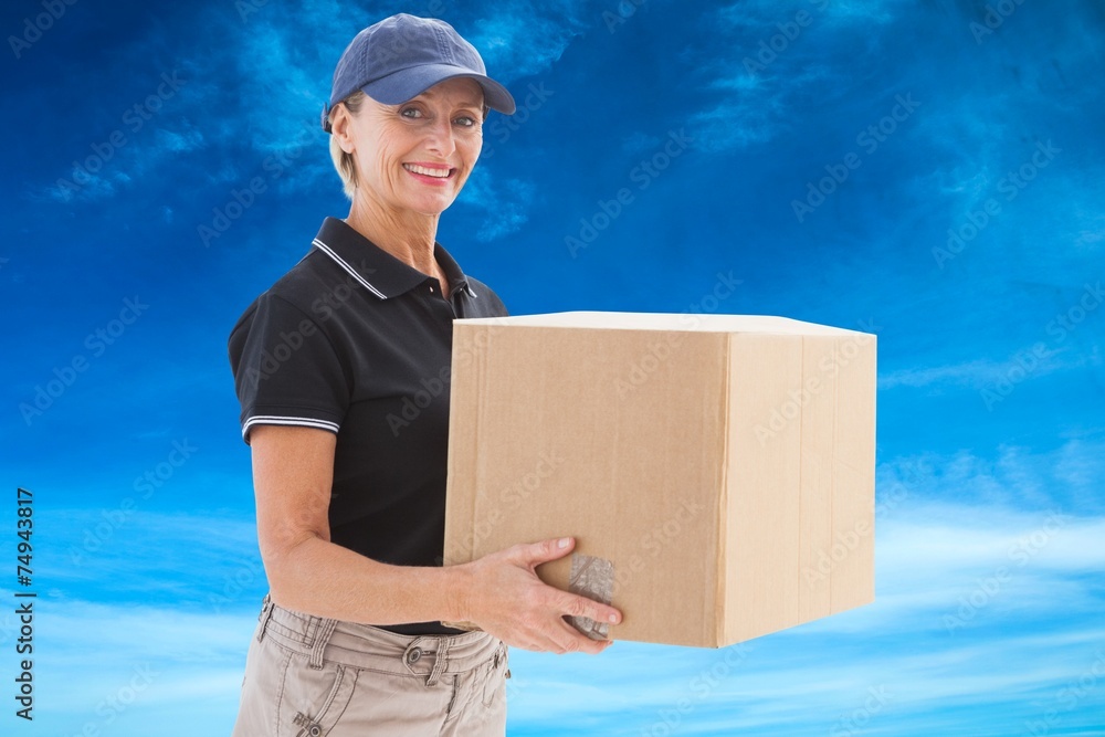 Composite image of happy delivery woman holding cardboard box Composite image of happy delivery woman holding cardboard box
