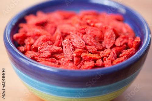 dried goji berries in colored bowl photo