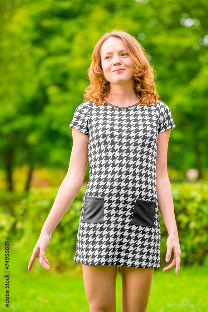 Fototapeta premium happy girl in a dress on a background of green park