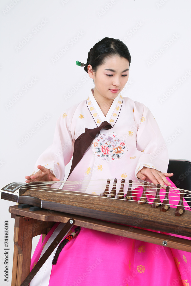 가야금을 뜯는 한복 입은 여성