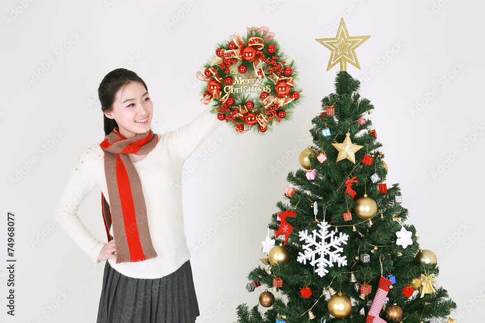 크리스마스 트리 옆의 젊은 한국 여성