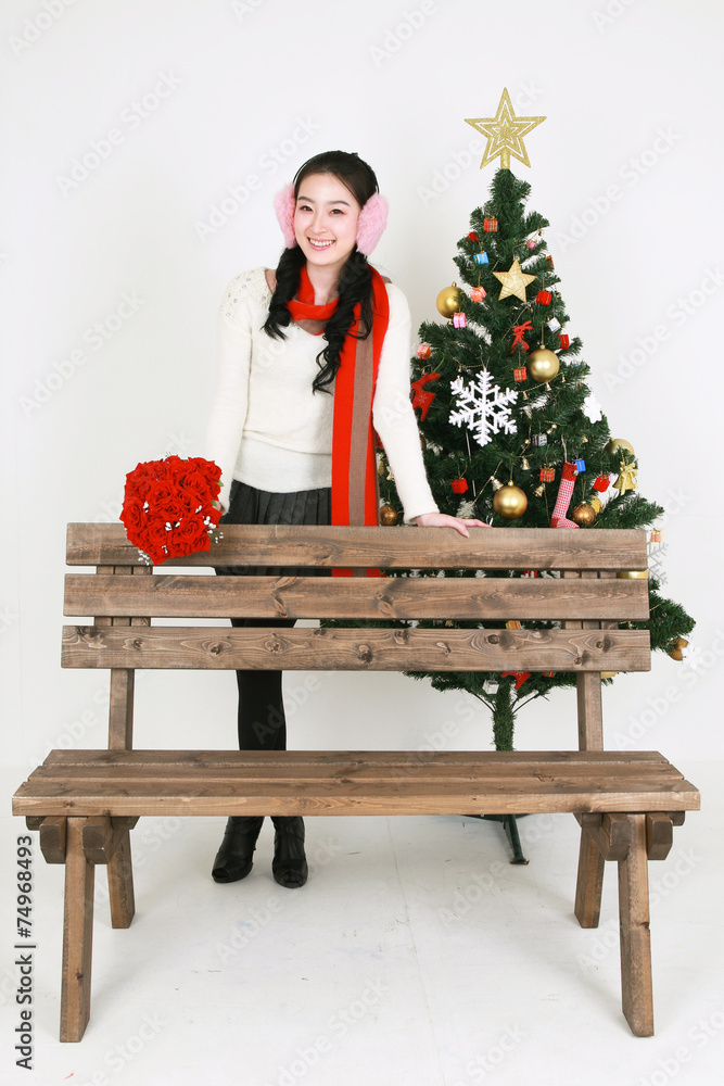 크리스마스 트리 옆의 젊은 한국 여성