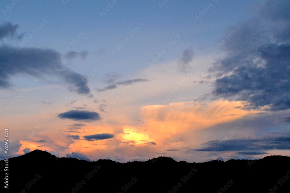 background sun filtered cloudscape silhouetted mountains