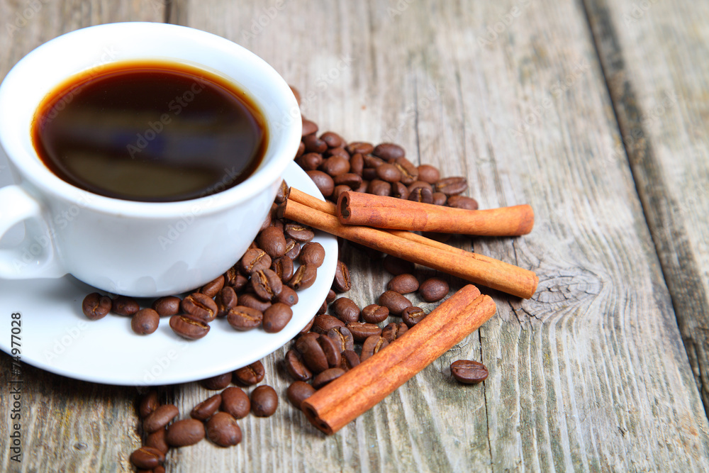 Cup of coffee, beans and cinnamon sticks Cup of coffee, beans and cinnamon sticks