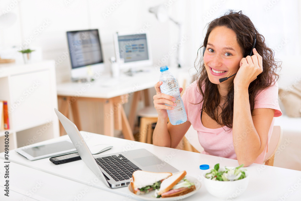 Young attractive student drinking water while working Young attractive student drinking water while working