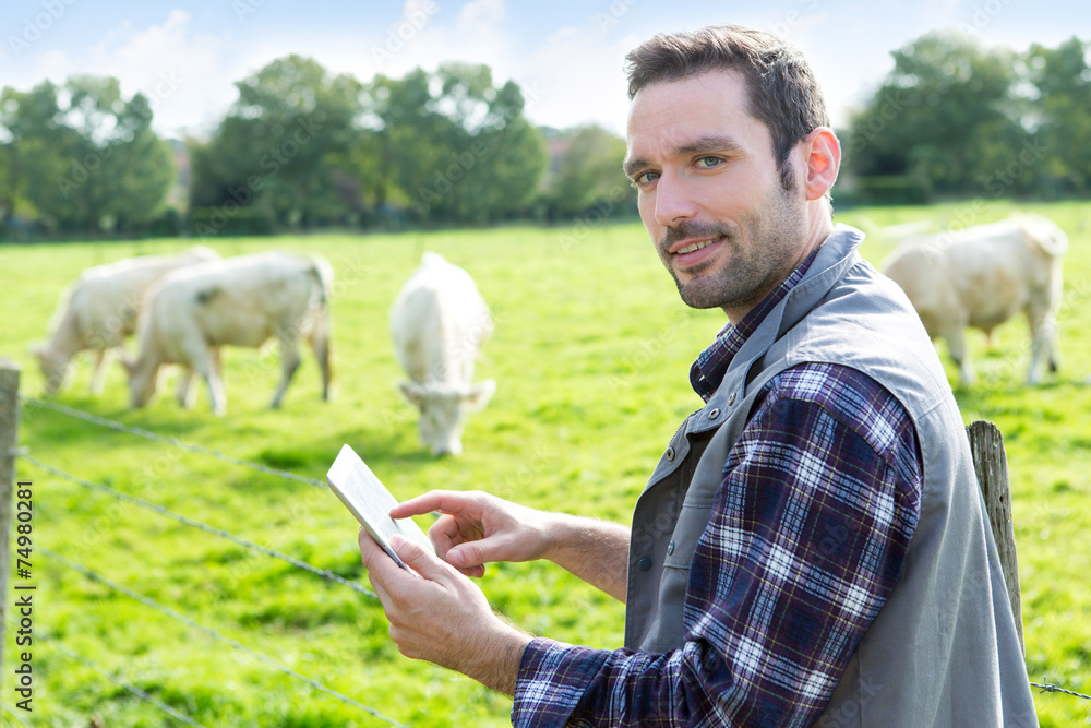 Young attractive farmer using tablet in a field Young attractive farmer using tablet in a field