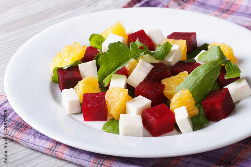 Fresh beet salad with oranges, cheese and arugula on a table Fresh beet salad with oranges, cheese and arugula on a table