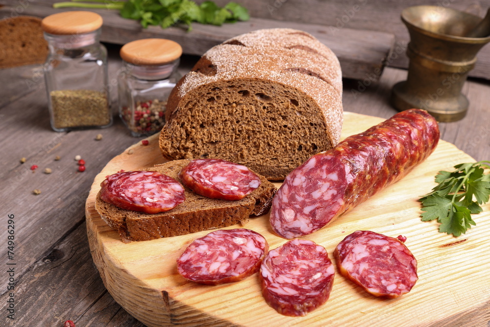 Sliced salami and bread on a cutting board Sliced salami and bread on a cutting board