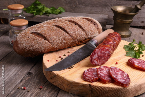 Salami, bread and a knife on the kitchen table