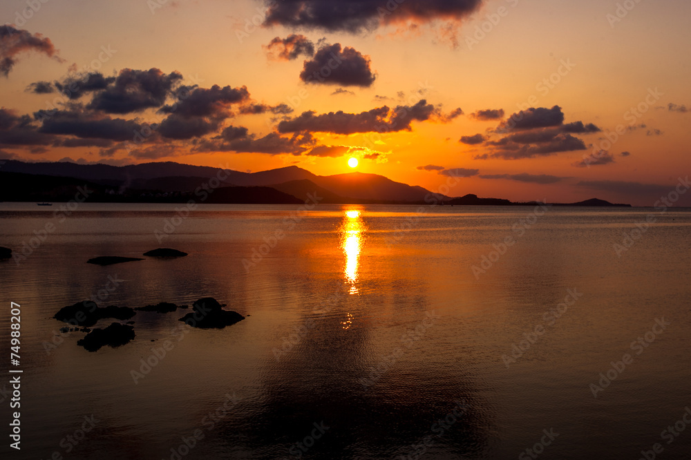 orange sunset at the sea with mountains silhouettes