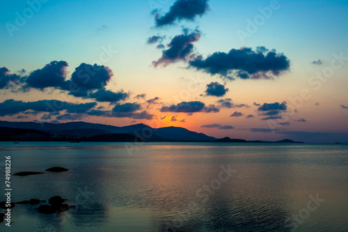 twilight over a rocky coast and mountains in the background