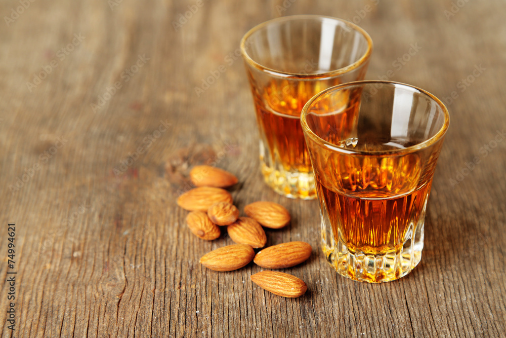 Dessert liqueur Amaretto with almond nuts, on wooden table Dessert liqueur Amaretto with almond nuts, on wooden table