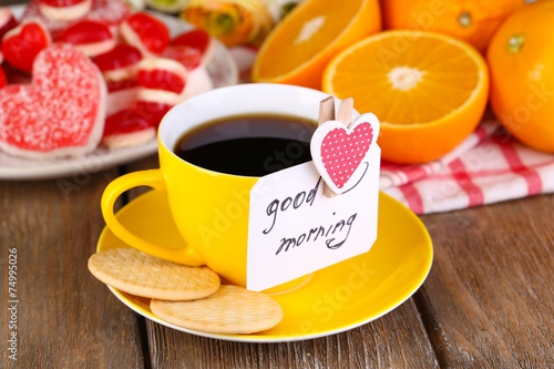 Fototapeta Cup of tea with card that says good morning on table close-up