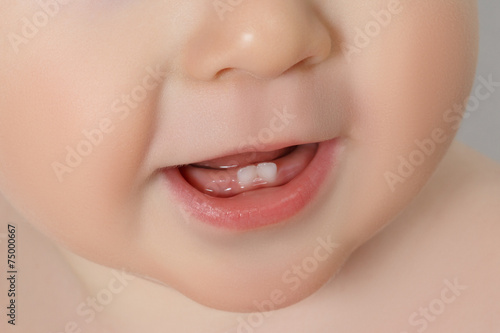 Smiling baby with first two baby teeth