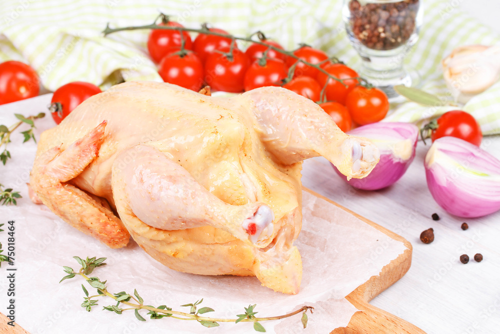 Fresh raw chicken prepared for roast with thyme and tomatoes Fresh raw chicken prepared for roast with thyme and tomatoes