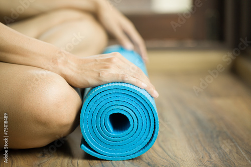 Young woman holding a yoga mat