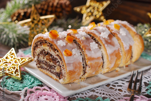 sliced christmas poppy seed cake with icing and snowflake sprink photo