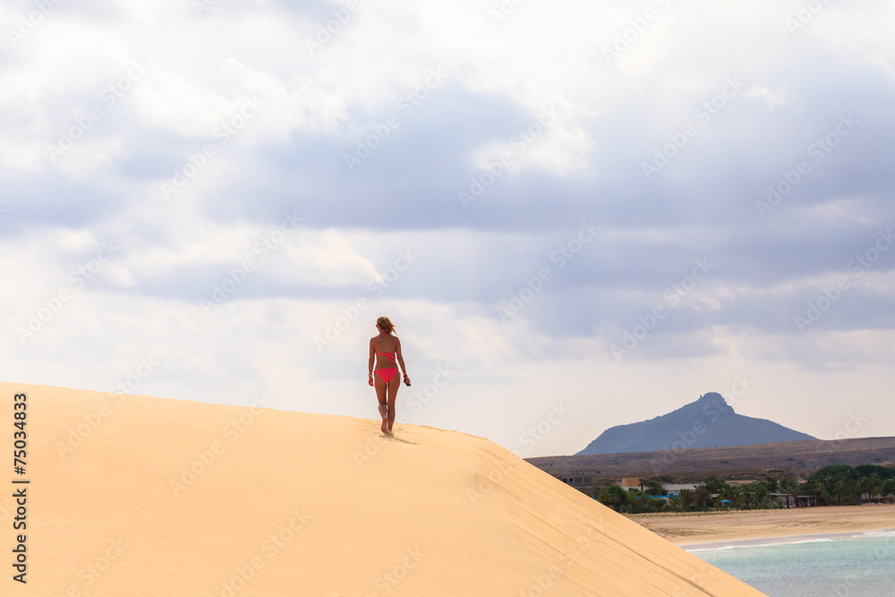 woman walking on the yellow sand hill in the early morning in Bo