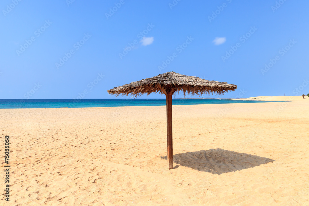 Beach scenery with parasol in Boavista, Cape Verde