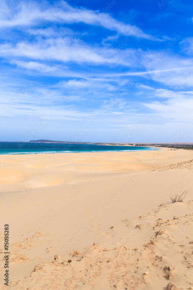 Sand dunes near to the ocean with cloudy blue sky, Boavista, Cap
