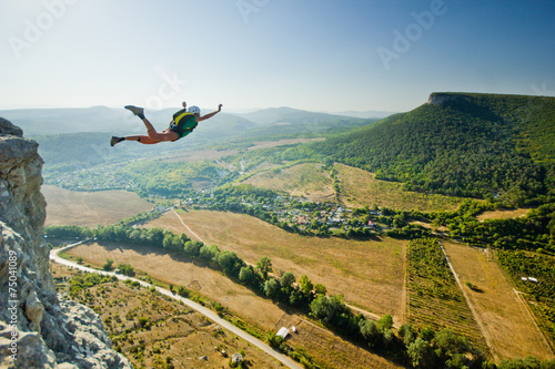 base-jumper jumps from the cliff photo