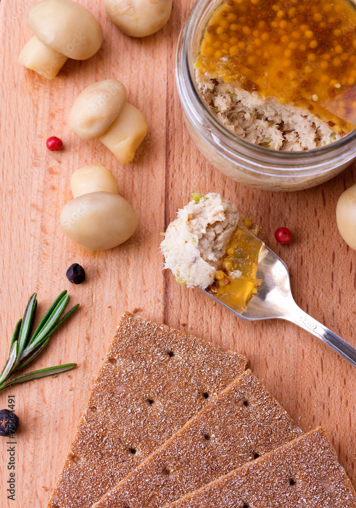 Chicken pate in jar and crispbread on wood cutting board Chicken pate in jar and crispbread on wood cutting board