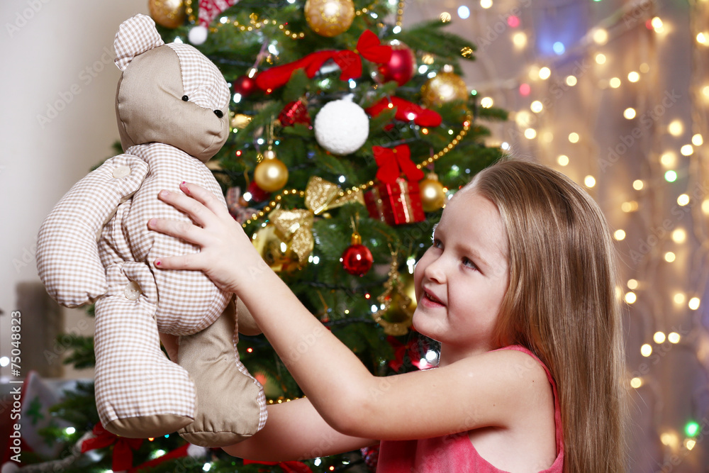Little girl with teddy bear on bright background