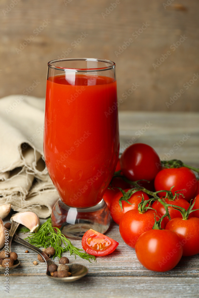 Glass of tasty tomato juice and fresh tomatoes on wooden table Glass of tasty tomato juice and fresh tomatoes on wooden table