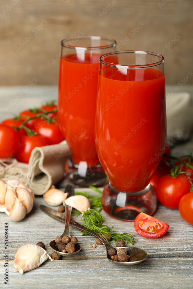 Glasses of tasty tomato juice and fresh tomatoes on wooden Glasses of tasty tomato juice and fresh tomatoes on wooden