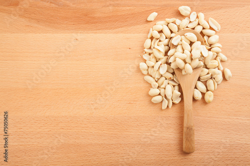 Peeled peanuts with wooden spoon