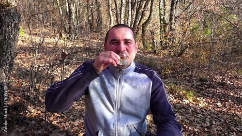 Man drinking alcohol in a forest photo