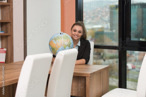 Beautiful Young Woman Holding A Globe At Office