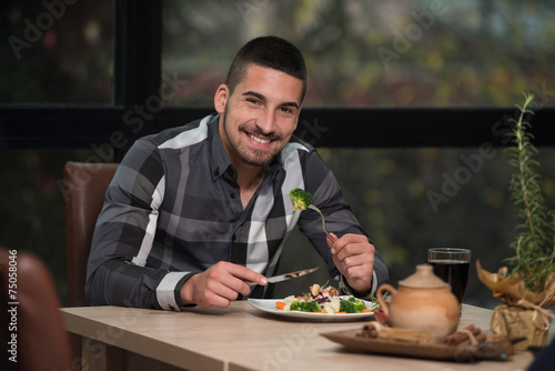Young Handsome Man Eating At A Restaurant