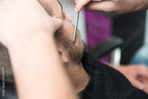 Hairdresser Shaving Man's Chin With A Straight Razor