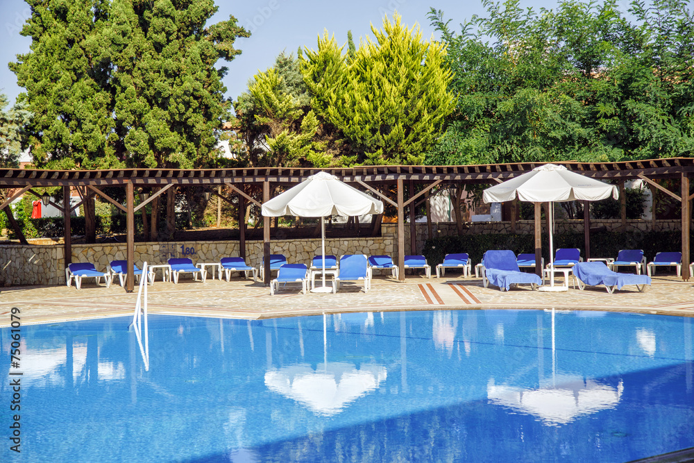 large swimming pool with sun loungers and parasols