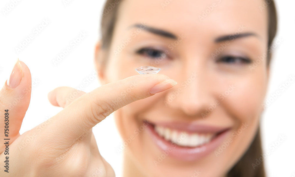 Contact lens: Young woman holding contact lens on finger in fron Contact lens: Young woman holding contact lens on finger in fron