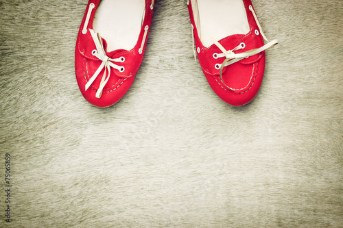 top view of red worn woman shoes over wooden textured background