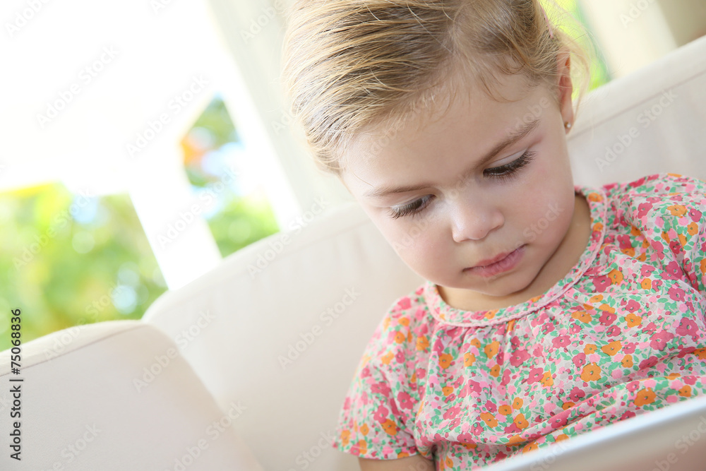 Little girl in sofa connected with digital tablet Little girl in sofa connected with digital tablet