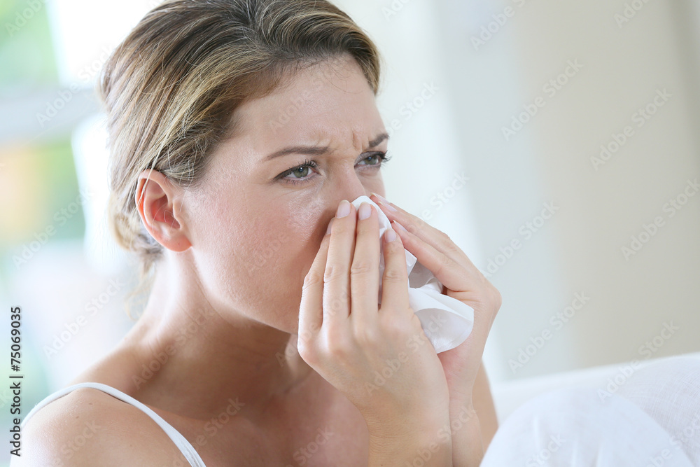 Portrait of womanwith allergy blowing her nose Portrait of womanwith allergy blowing her nose