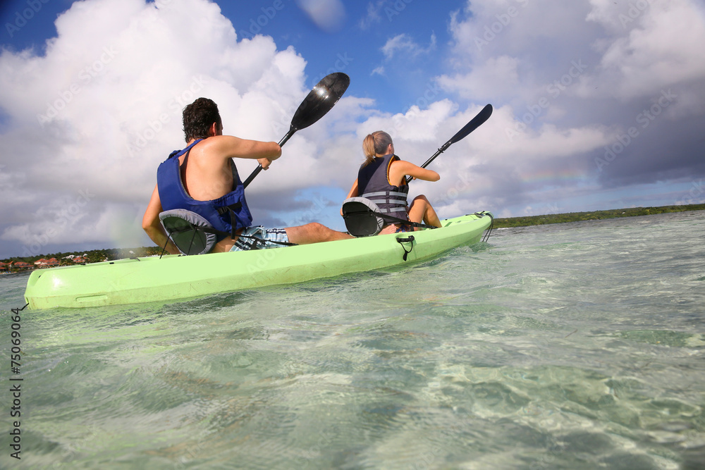 Couple canoeing in lagoon of West French indies