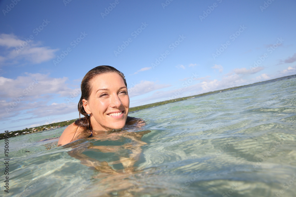 Portrait of smiling woman enjoying swimming in lagoon
