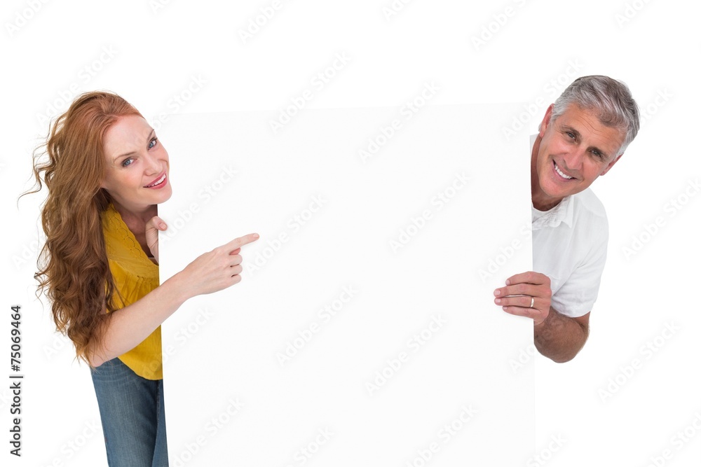 Casual couple showing a poster Casual couple showing a poster