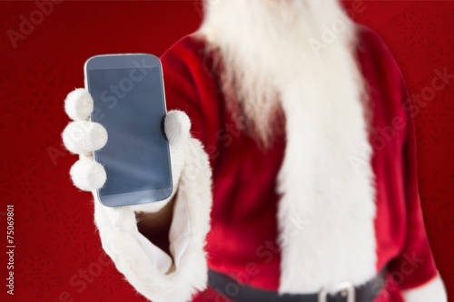 Composite image of santa claus showing smartphone