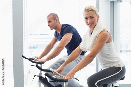Fit couple working on exercise bikes at gym © WavebreakMediaMicro