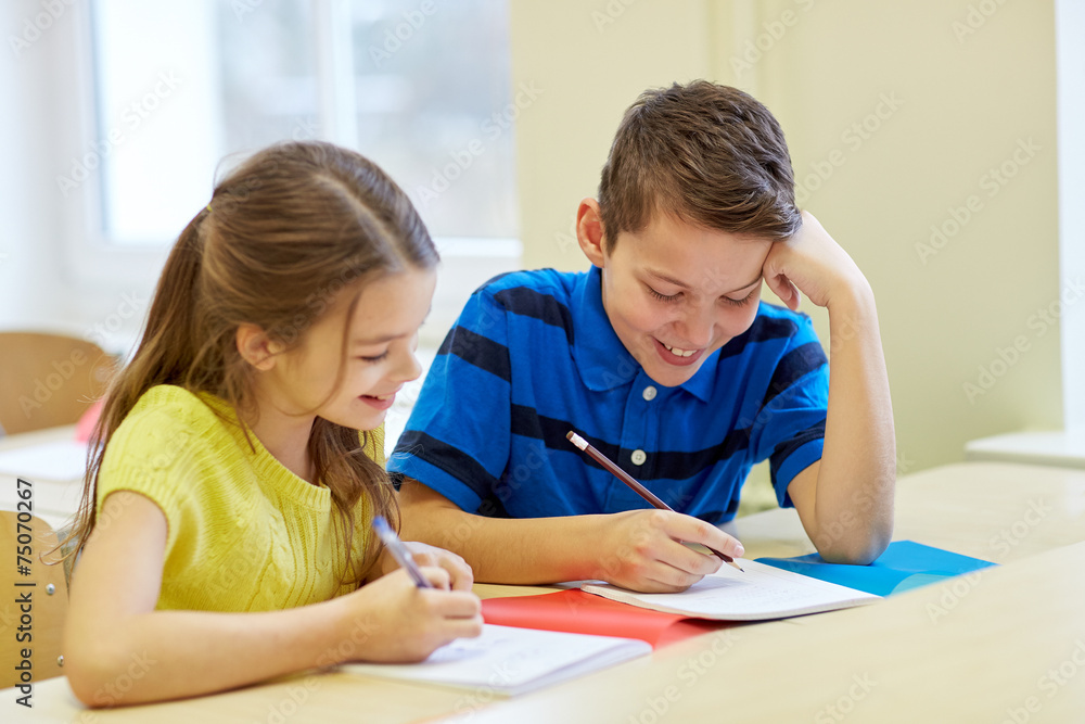 group of school kids writing test in classroom group of school kids writing test in classroom