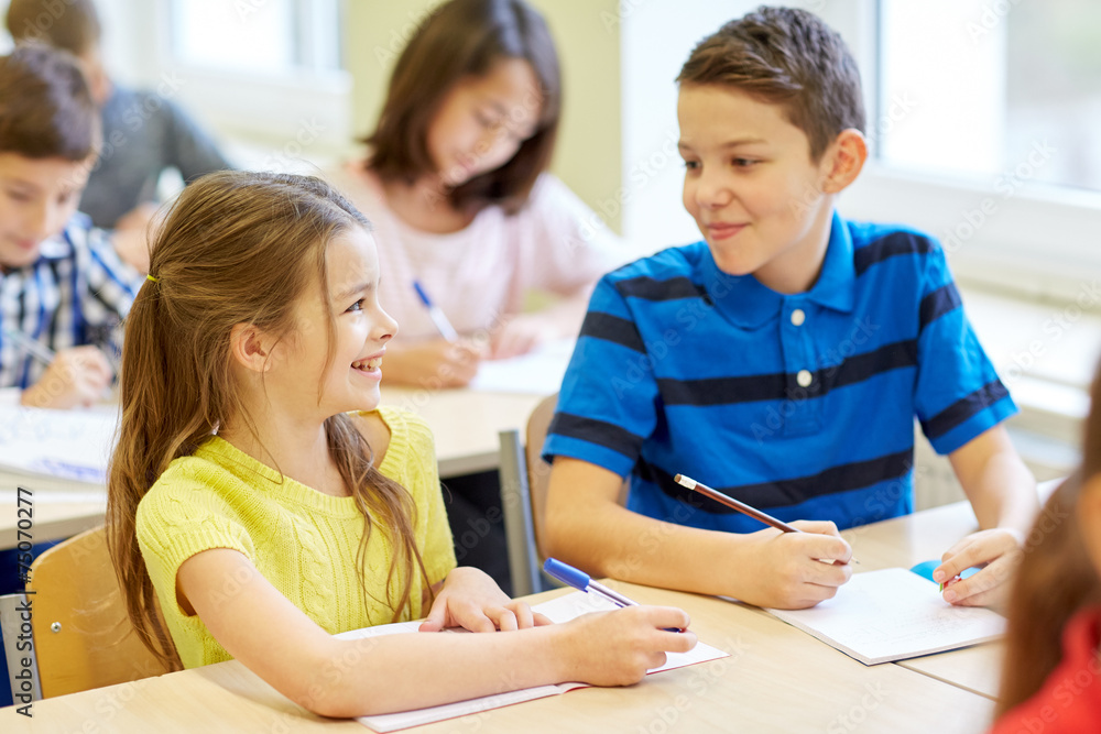 group of school kids writing test in classroom group of school kids writing test in classroom