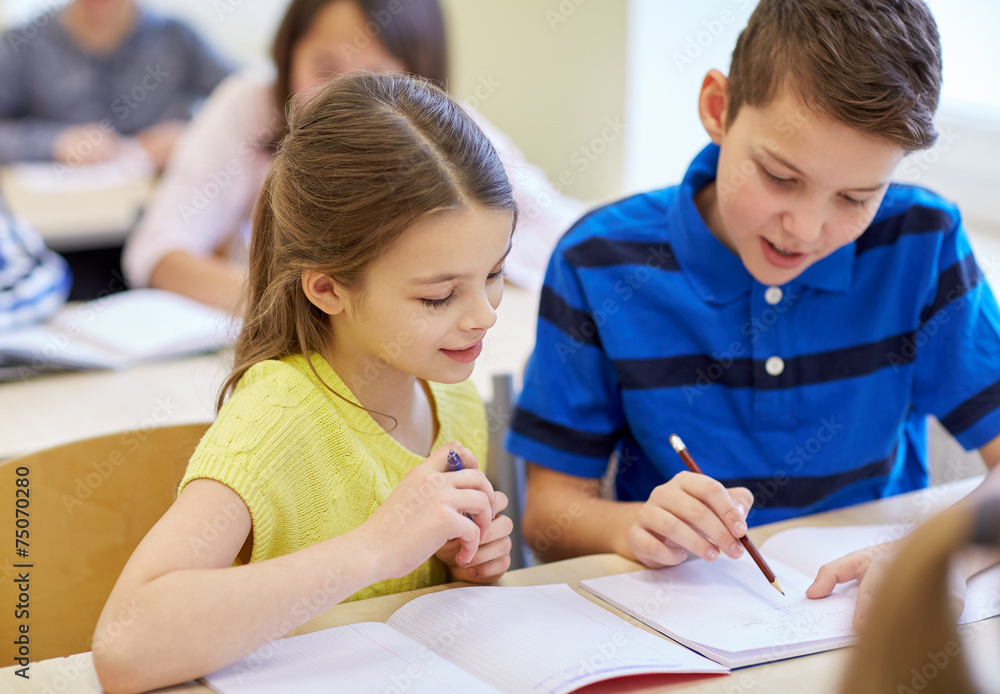 group of school kids writing test in classroom group of school kids writing test in classroom