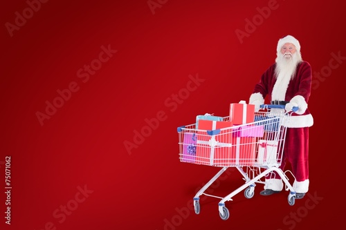 Composite image of santa pushes a shopping cart with presents © WavebreakMediaMicro